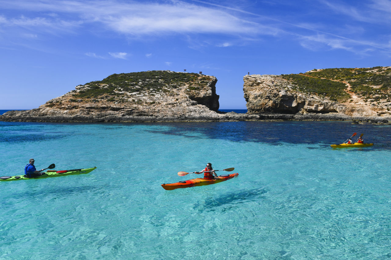 a family kayaking around the blue lagoon in Malta